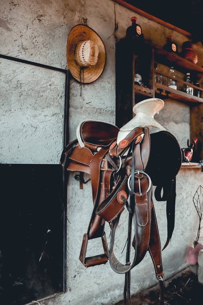 A classic leather saddle and straw hat in a rustic interior in Mexico City, Mexico.